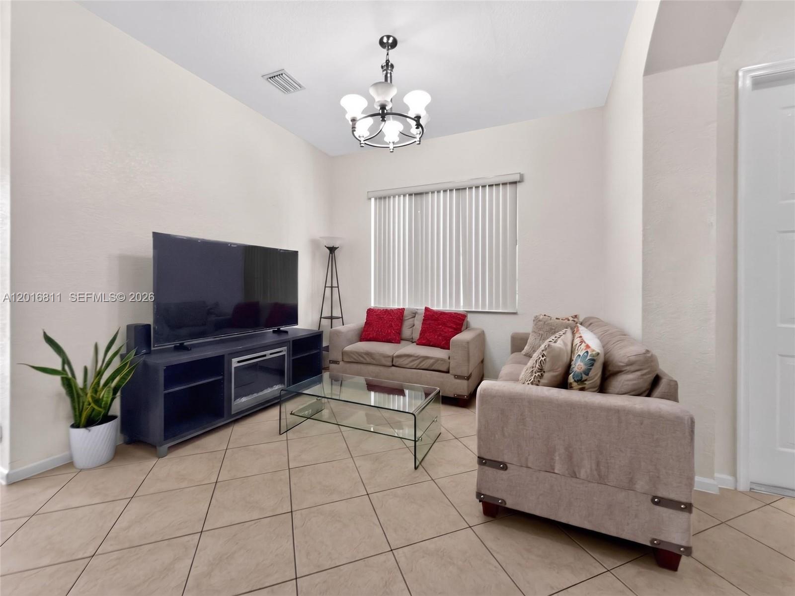 12415 Southwest 42nd Street Miramar, FL 33027 - Photo 7 of 21 a living room with furniture and a flat screen tv