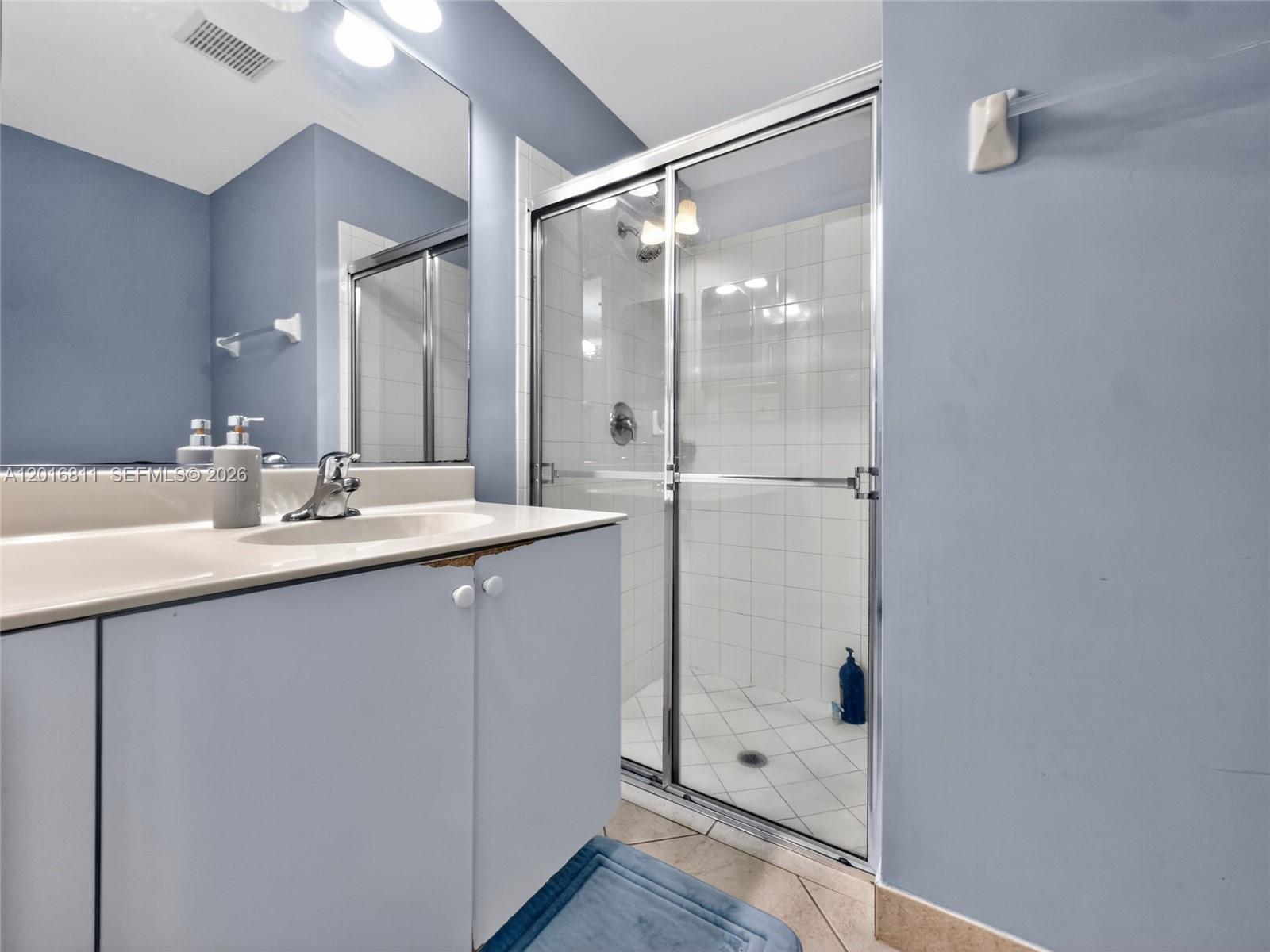 12415 Southwest 42nd Street Miramar, FL 33027 - Photo 9 of 21 a bathroom with a shower sink vanity and mirror
