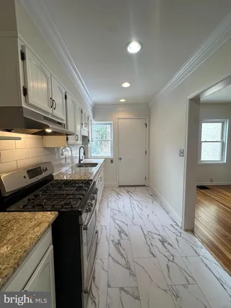 a kitchen with granite countertop a stove and cabinets