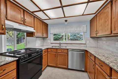 a kitchen with stainless steel appliances granite countertop a sink a stove and cabinets