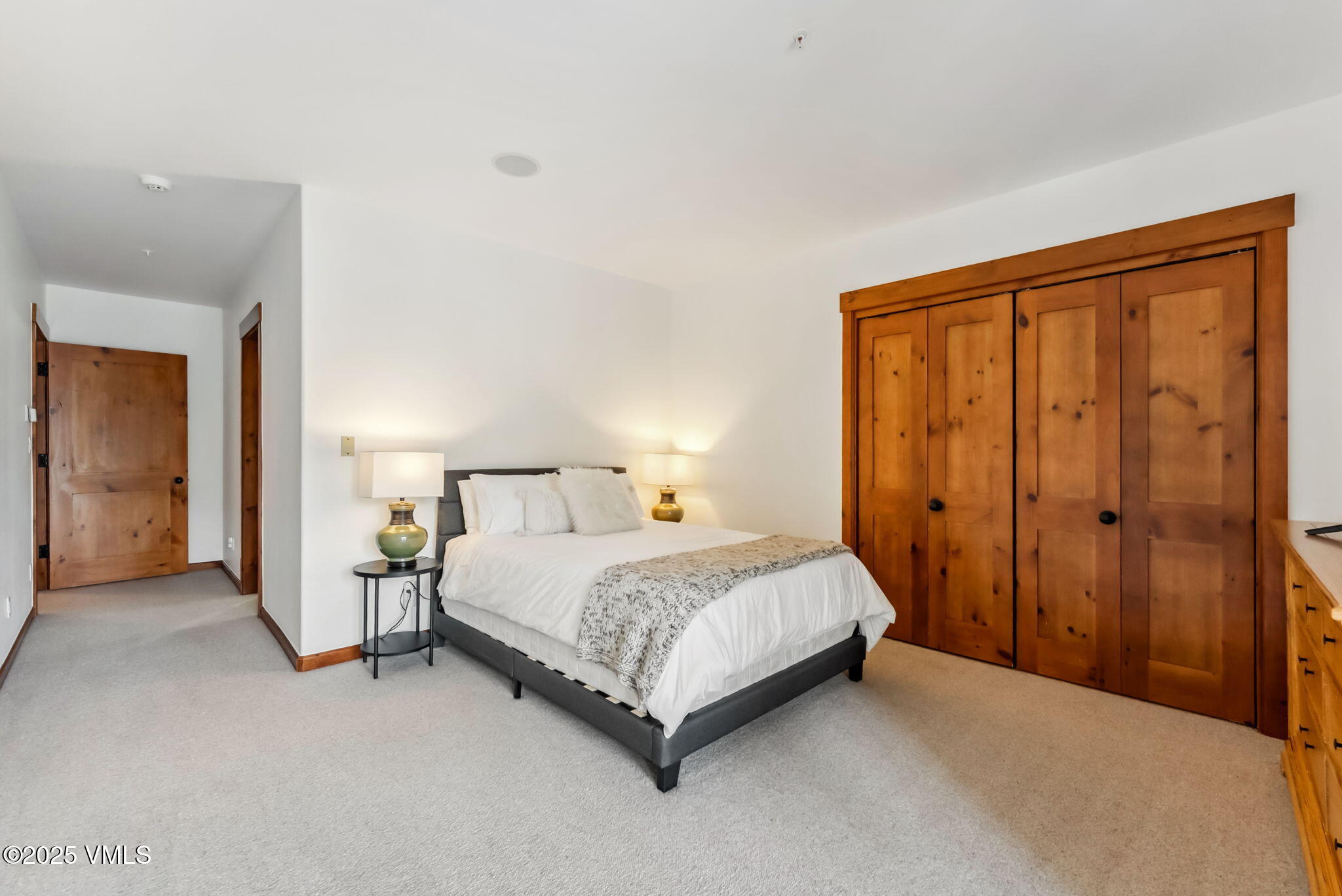 268 Bachelor Ridge Road Avon, CO 81620 - Photo 14 of 25 a spacious bedroom with a bed and a lamp