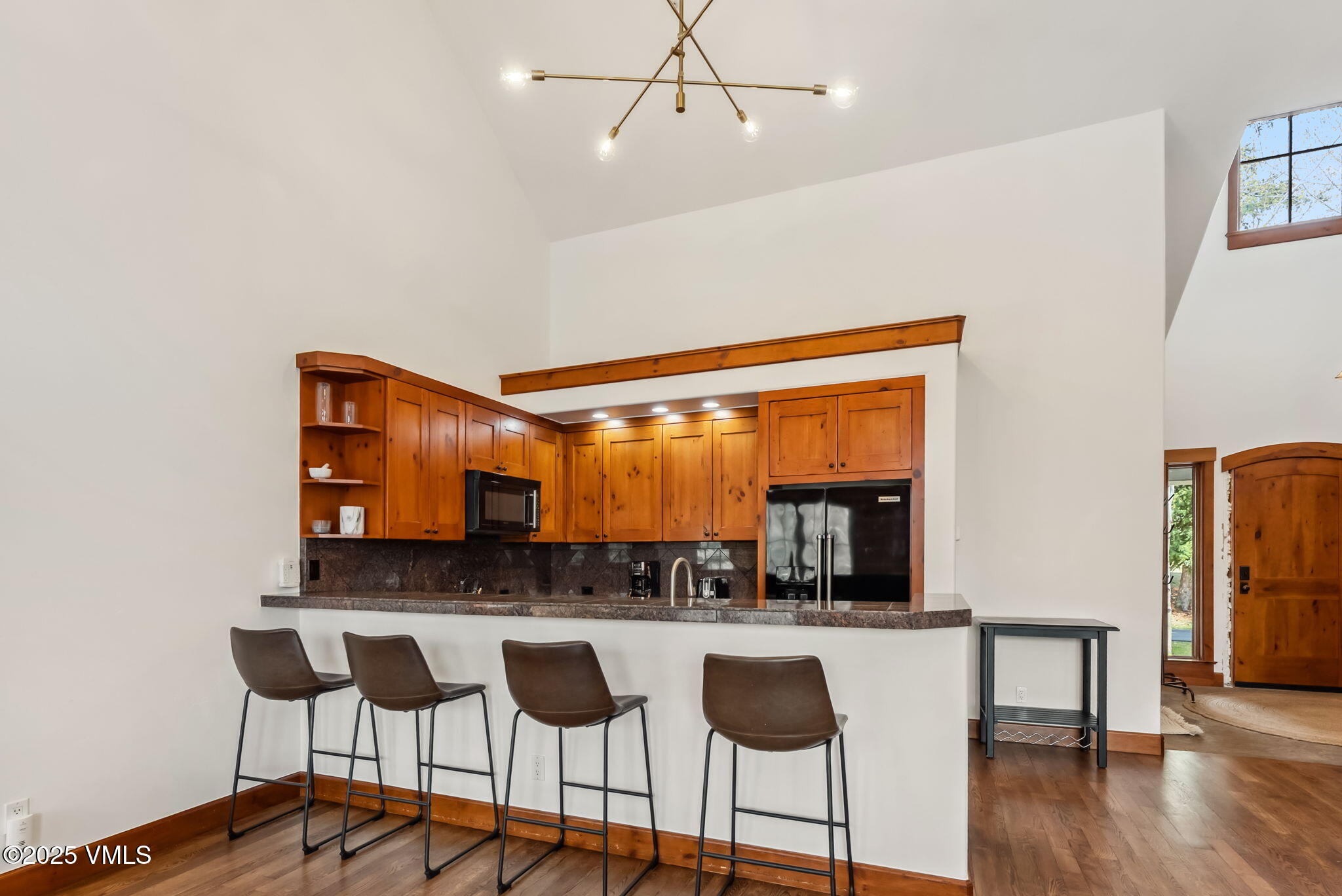 268 Bachelor Ridge Road Avon, CO 81620 - Photo 9 of 25 a kitchen with stainless steel appliances kitchen island granite countertop a dining table chairs and granite counter top