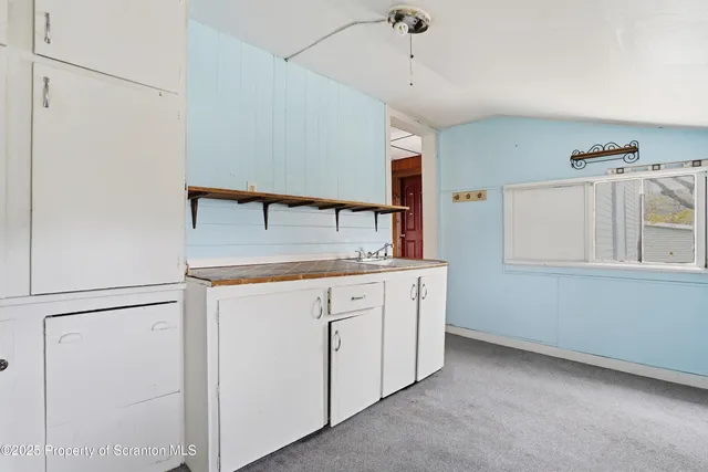 a kitchen with granite countertop cabinets appliances and a counter space