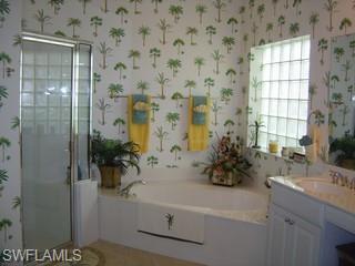 8582 Peppertree Way Naples, FL 34114 - Photo 6 of 8 a bathroom with a sink and mirror with bathtub