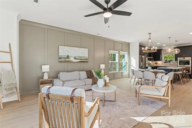 a living room with furniture and a view of kitchen
