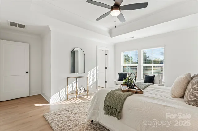 a bed room with a bed a chandelier and a window