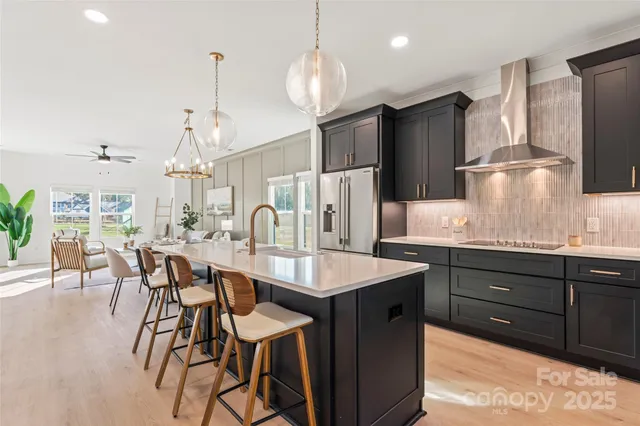 a kitchen with granite countertop a sink a center island stainless steel appliances and cabinets