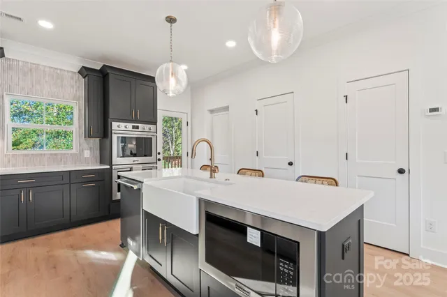 a kitchen with kitchen island a sink appliances and cabinets