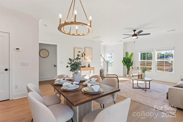 a dining room with furniture a chandelier and window