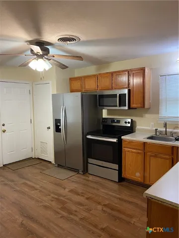 a kitchen with granite countertop a refrigerator stove and microwave