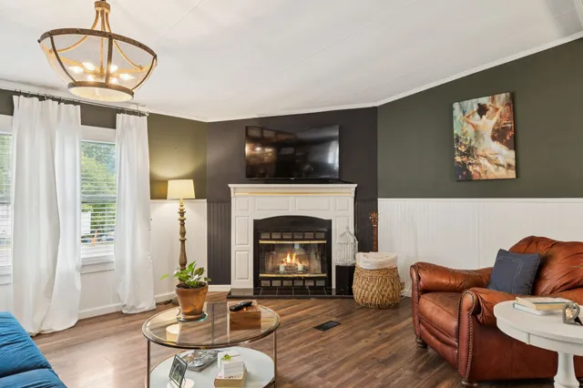a living room with fireplace furniture and a wooden floor