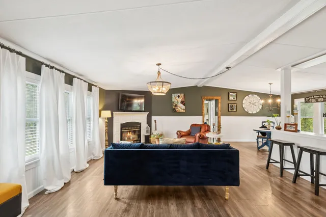 a dining room with furniture a chandelier and wooden floor