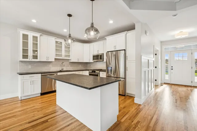 a kitchen with stainless steel appliances granite countertop a refrigerator a stove a sink and a refrigerator