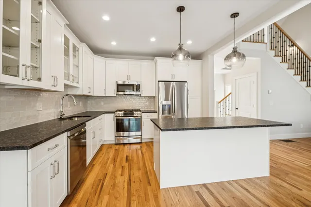 a kitchen with stainless steel appliances granite countertop a sink a stove and a refrigerator