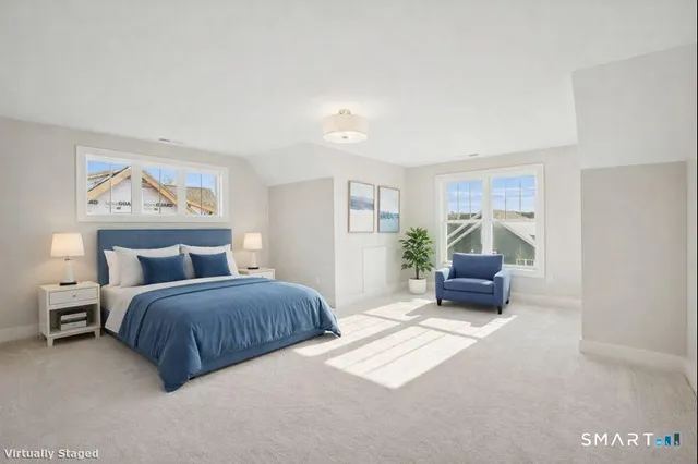 a spacious bedroom with a bed a couch and a potted plant