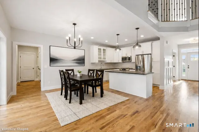 a view of a dining room and livingroom with furniture wooden floor a chandelier
