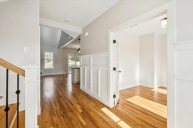 a view of a hallway view with wooden floor and staircase
