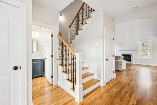 a view of a hallway with wooden floor and staircase