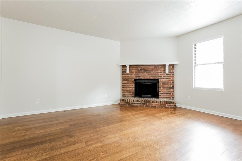 3352 Herrenhut Road Lithonia, GA 30038 - Photo 10 of 27 an empty room with wooden floor and fireplace