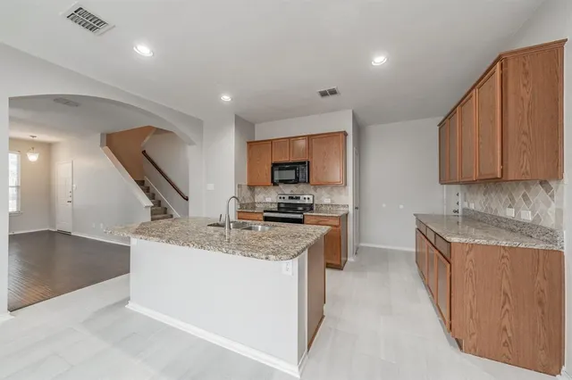 a view of a kitchen with granite countertop counter top space a sink and appliances