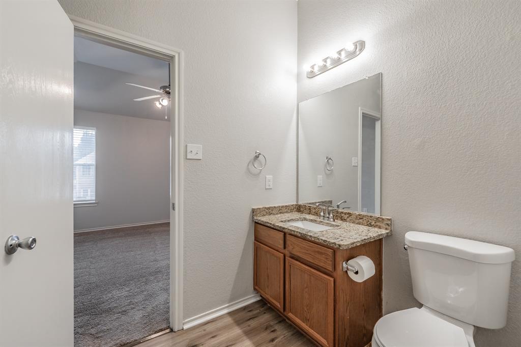 5446 Prairie Lane Grand Prairie, TX 75052 - Photo 22 of 39 a bathroom with a granite countertop toilet sink and mirror