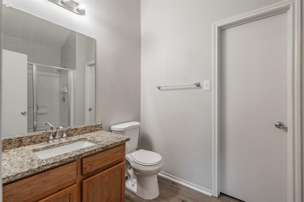 5446 Prairie Lane Grand Prairie, TX 75052 - Photo 23 of 39 a bathroom with a granite countertop sink toilet and shower
