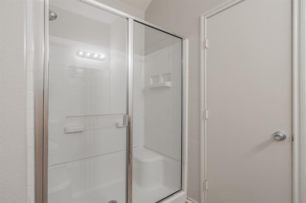 5446 Prairie Lane Grand Prairie, TX 75052 - Photo 24 of 39 a bathroom with a glass shower door
