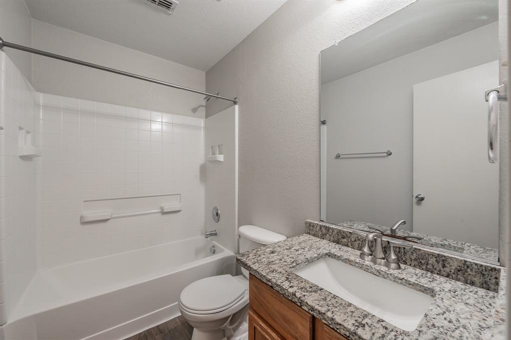 5446 Prairie Lane Grand Prairie, TX 75052 - Photo 28 of 39 a bathroom with a granite countertop sink toilet mirror and shower