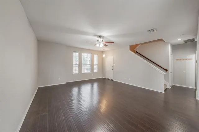 a living room with furniture a window and a ceiling fan