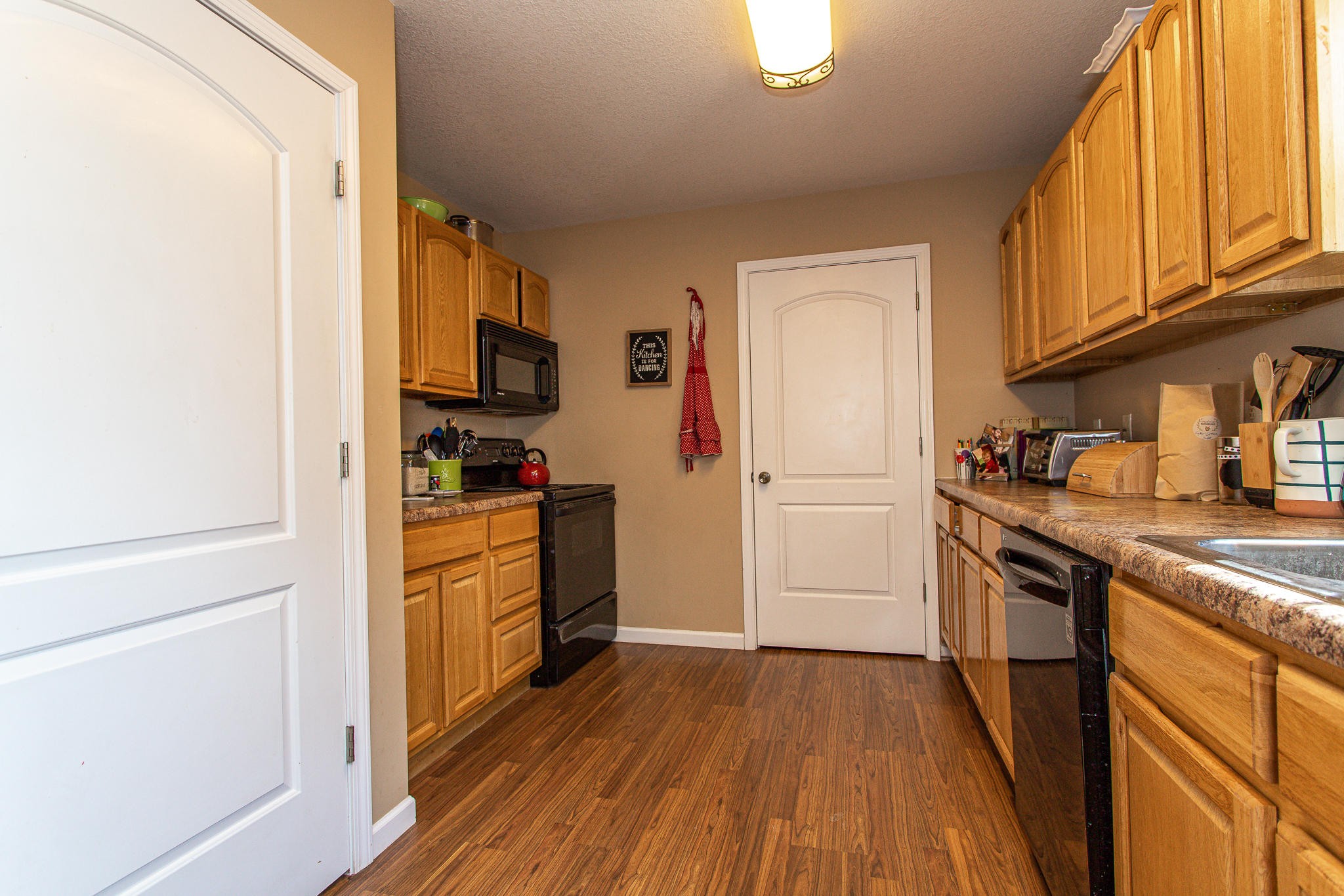 830 Collins Road Blaine, TN 37709 - Photo 13 of 34 a kitchen with a refrigerator stove and wooden cabinets