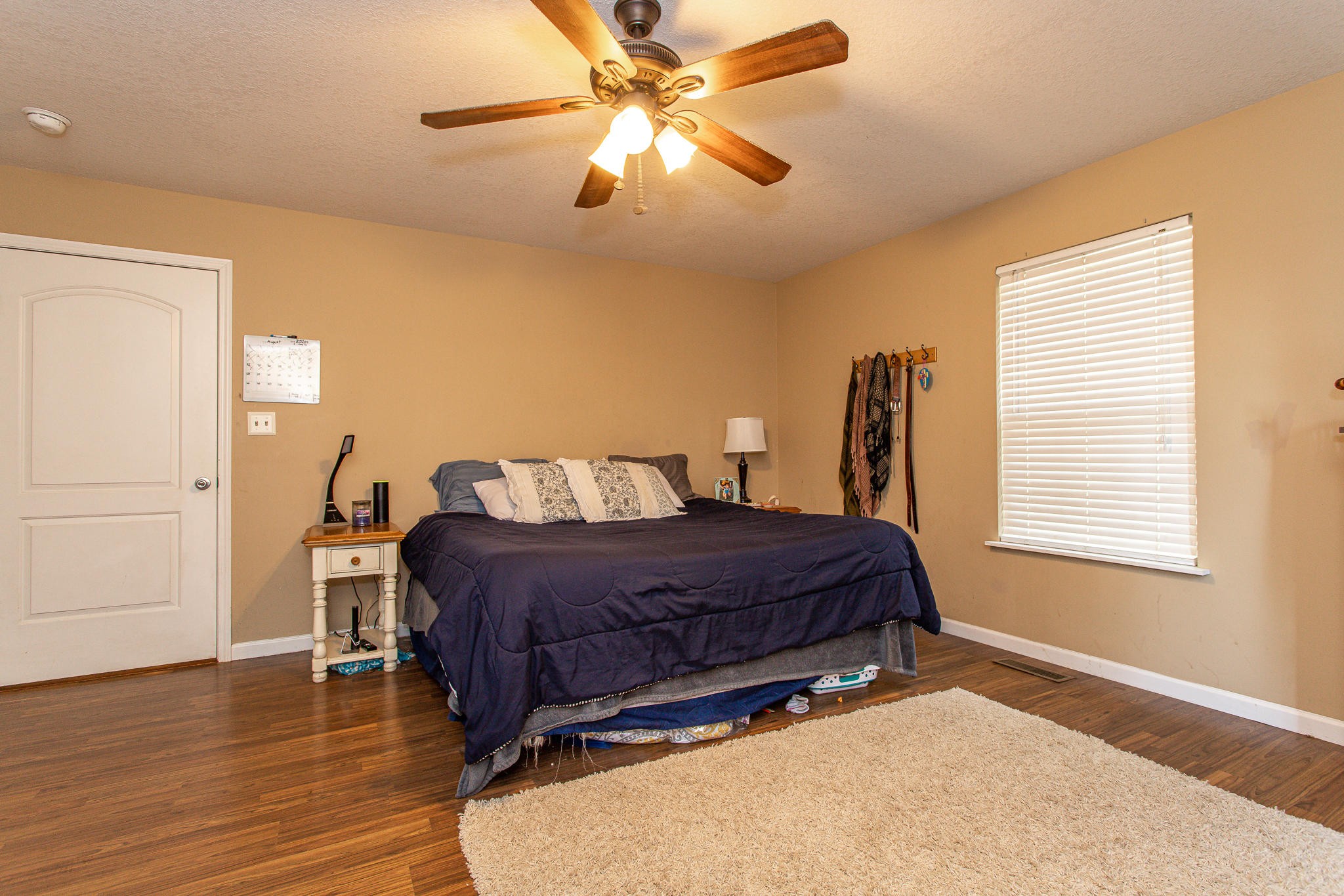 830 Collins Road Blaine, TN 37709 - Photo 15 of 34 a spacious bedroom with a bed and a chandelier
