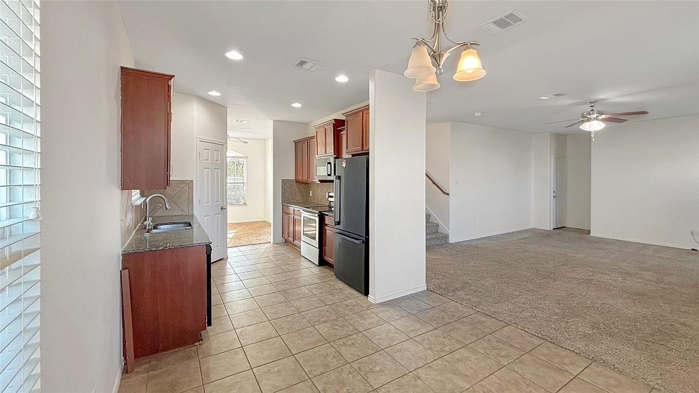 133 Langtry Lane Jarrell, TX 76537 - Photo 22 of 27 View of the kitchen with fridge and living room int he back of photo & dining room in the front of the house.