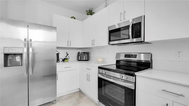 a kitchen with cabinets stainless steel appliances and a counter space