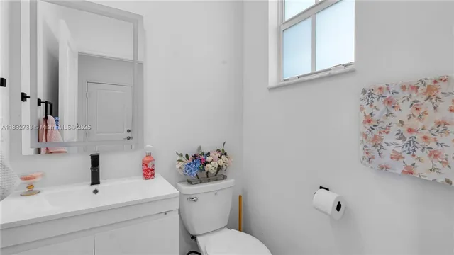 a bathroom with a sink mirror and toilet