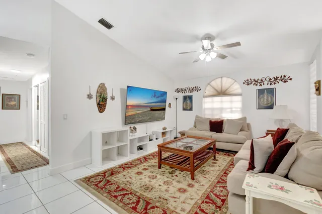 a view of a dining room with furniture and a chandelier fan