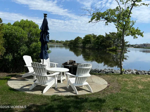 a view of a lake with table and chairs