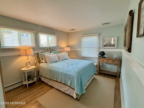 a bedroom with a bed and a dresser next to a window
