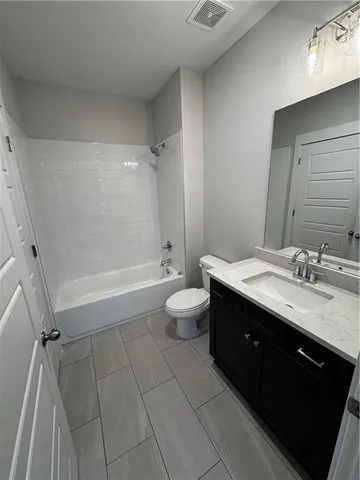 a spacious bathroom with a double vanity sink toilet mirror and a bathtub