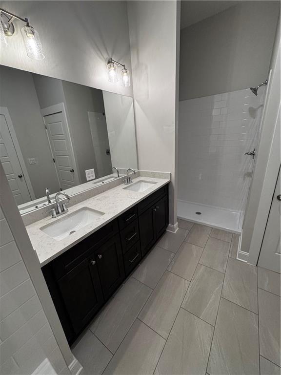 1777 Temple Avenue, Unit P Atlanta, GA 30337 - Photo 17 of 22 a bathroom with a double vanity sink a mirror and a bathtub