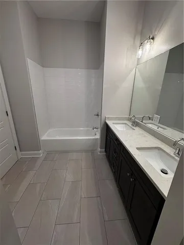 a bathroom with a double vanity sink a mirror and a bathtub