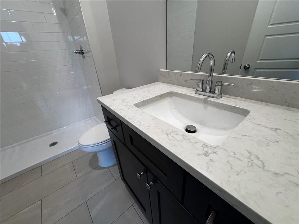 1777 Temple Avenue, Unit P Atlanta, GA 30337 - Photo 19 of 22 a bathroom with a granite countertop sink a mirror and shower