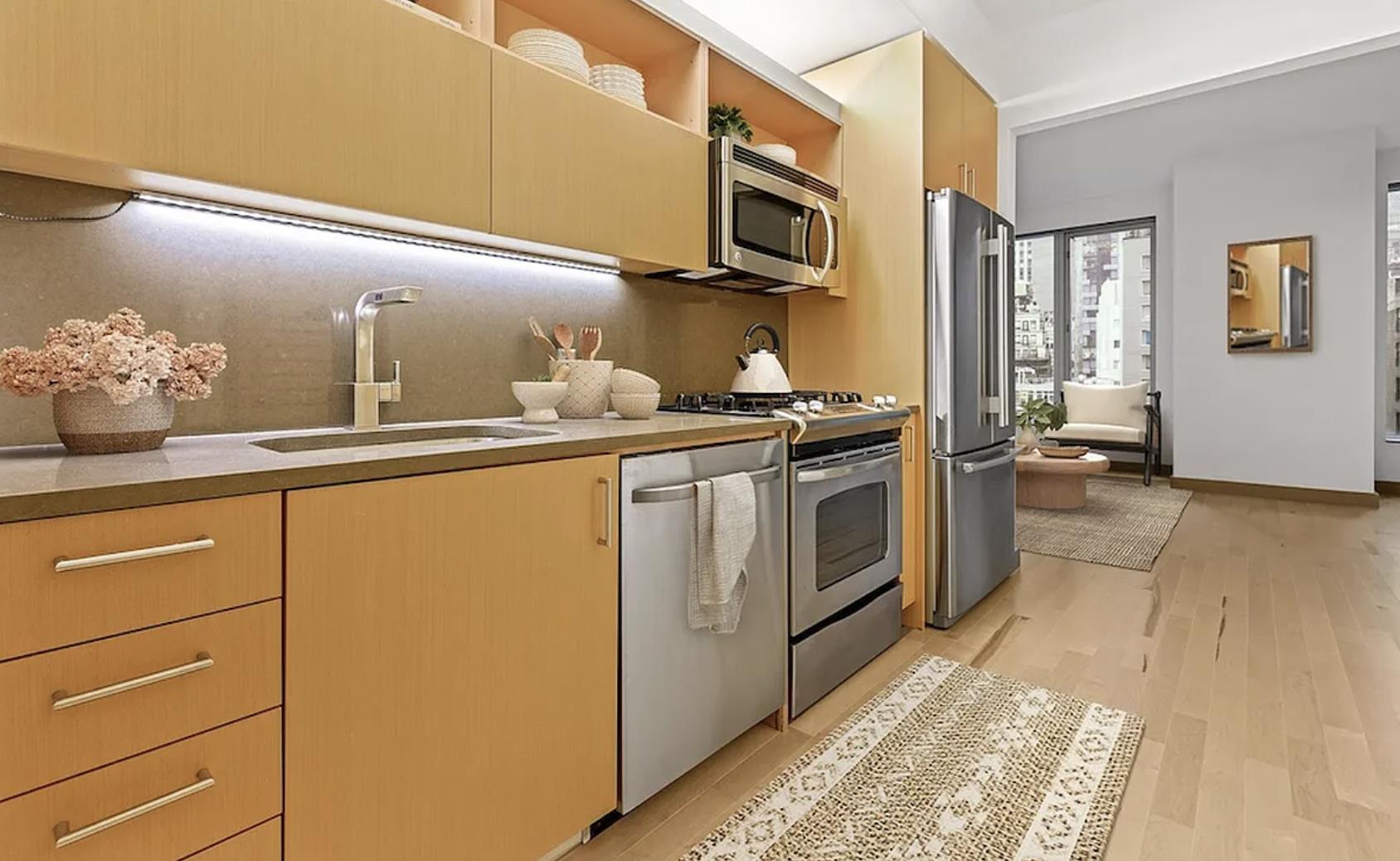 a kitchen with stainless steel appliances granite countertop a sink a stove and a refrigerator