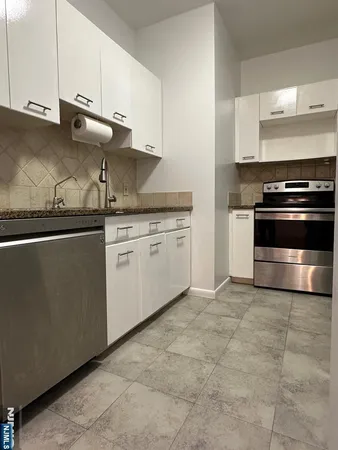 a kitchen with granite countertop a stove and a sink