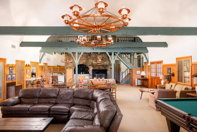 a view of a white house next to a yard and a large tree