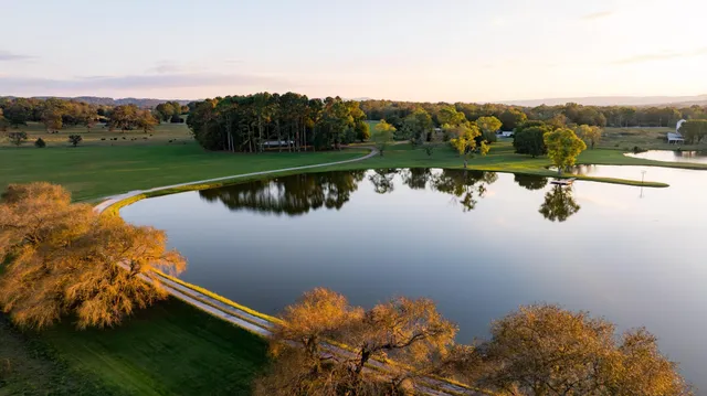 a view of a swimming pool with a yard and a fountain