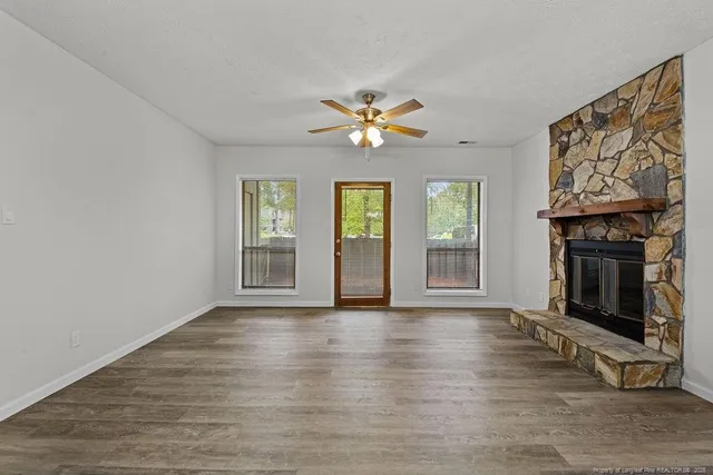 a view of an empty room with window and fireplace