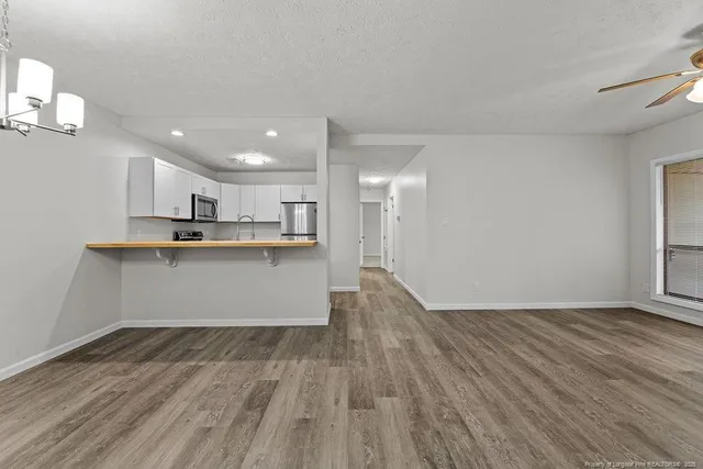 a kitchen with stainless steel appliances granite countertop a wooden floor and a sink
