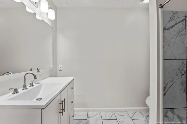 a bathroom with a sink mirror and vanity
