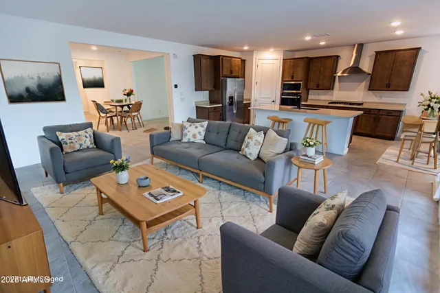 a living room with furniture kitchen view and a window