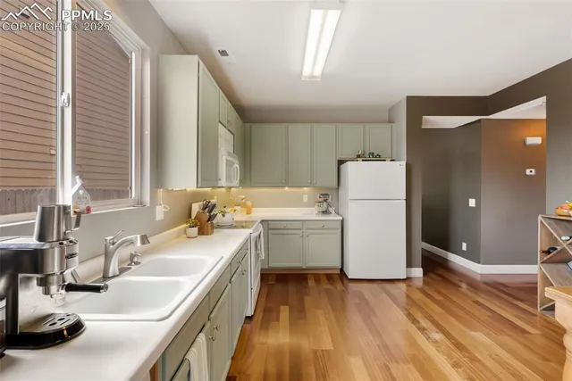 a dining room with wooden floor a chandelier fan a wooden table and chairs